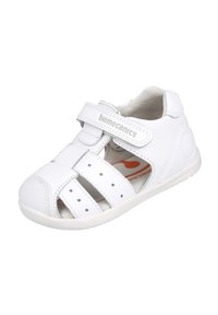 Sandalia de cuero blanco con puntera cerrada, múltiples tiras y cinta de velcro. Presenta un interior acolchado y una suela de goma texturizada.