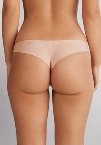 Beige naadloze katoenen hipsteronderbroek met een lage tailleband, een gladde textuur en een minimalistisch ontwerp voor beperkte bedekking.