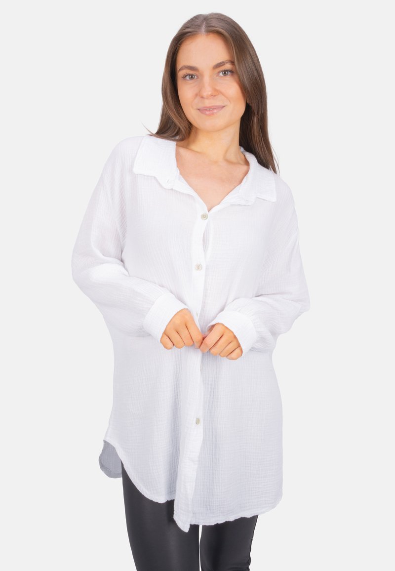 White long-sleeve shirt made of lightweight, textured fabric. Features a collar, button closure, and a curved hem.
