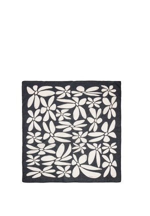Czarna, kwadratowa tkanina z abstrakcyjnym białym wzorem kwiatowym, zawierająca różnorodne kształty i rozmiary płatków równomiernie rozmieszczone na powierzchni.