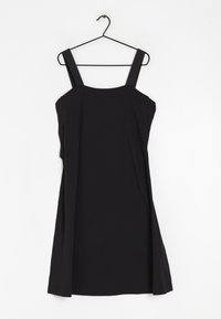 Robe noire sans manches avec des larges bretelles, un corsage ajusté et une jupe évasée. Fabriquée en tissu léger et lisse.