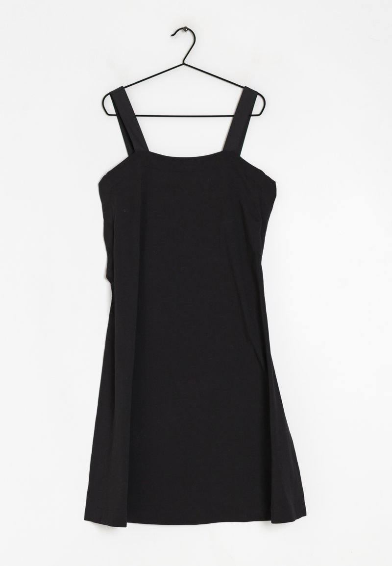 Robe noire sans manches avec des larges bretelles, un corsage ajusté et une jupe évasée. Fabriquée en tissu léger et lisse.