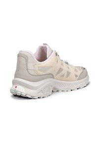 Chaussure de sport beige clair et grise avec panneaux en mesh, semelle épaisse texturée et col rembourré, vue de profil arrière sur fond blanc.