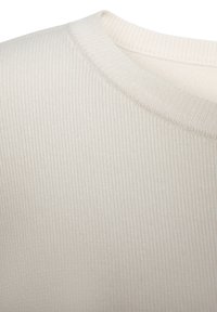 Cremefarbener gerippter Stoff mit strukturiertem Finish und klassischem Rundhalsausschnitt. Weiches, dehnbares Material mit einem glatten und haltbaren Strickmuster.
