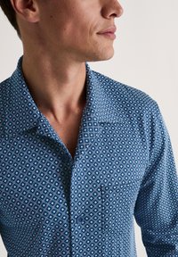Gestreepte blauwe button-up shirt met een geometrisch patroon. Beschikt over een puntige kraag, korte mouwen en een borstzak. Gladde stoftextuur.