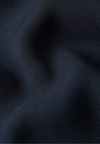 Tejido texturizado de color azul marino con un tejido fino y apretado, que muestra arrugas y pliegues, lo que indica flexibilidad y suavidad.