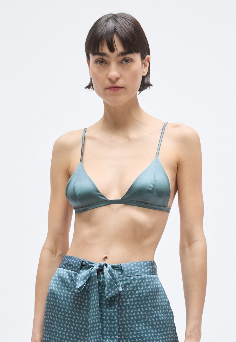 Reggiseno a triangolo in raso turchese con spalline sottili, abbinato a pantaloni turchese con motivo, cintura annodata e design discreto. Tessuto liscio.