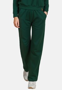 Donkergroene sweatpants van zachte stof, met een elastische tailleband, zijzakken en een relaxte pasvorm.