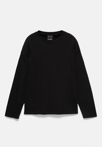 T-shirt noir à manches longues col rond, posé à plat, montrant un design simple sans motifs ni logos visibles sur le devant.