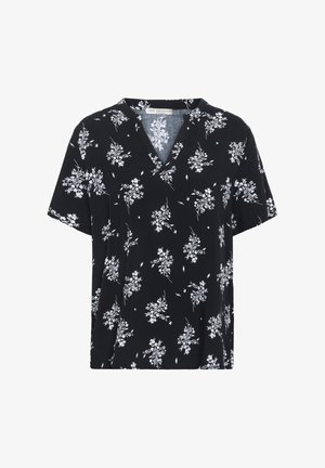 Svart kortärmad topp med V-ringning, prydd med ett vitt blommönster. Tillverkad av mjukt tyg med en lös passform.