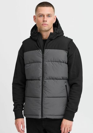 Gray puffer vest with a black hood. Features a zip front, two side pockets, and a padded design for insulation and comfort.