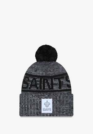 Berretto lavorato a maglia in nero e grigio con un pompon sulla parte superiore. Presenta il testo "SAINTS" e un'etichetta con il logo sulla parte anteriore. Texture morbida.