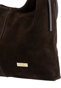 Bruine suède handtas met een zachte structuur, voorzien van een opvallende gouden "Venezia" logo-plaat en strakke grijze leren accenten.