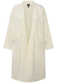 Roba beige leggera con vestibilità ampia, dotata di maniche larghe e due tasche frontali. Realizzata in tessuto morbido con un design minimalista.