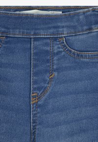 Denim jeans in een vervaagde blauwe kleur, met een hoge taille, gouden stiksels en voorzakken. Glad textuur met een klassiek vijfzakkenontwerp.