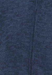 Sötét tengerészkék kötött pulóver, texturált mintázattal és finom eltérésekkel, középen látható varrással.
