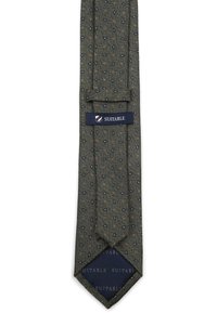 Groene stropdas met een gestructureerd patroon van kleine marineblauwe ovalen en rode stippen. Afgewerkt met een marineblauwe label met de tekst "SUITABLE."