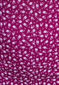Puuvillakangas sügava magenta taustaga, millel on kogu pinnal hajutatud väikesed valged lillemustrid ja peened lehedetailid.