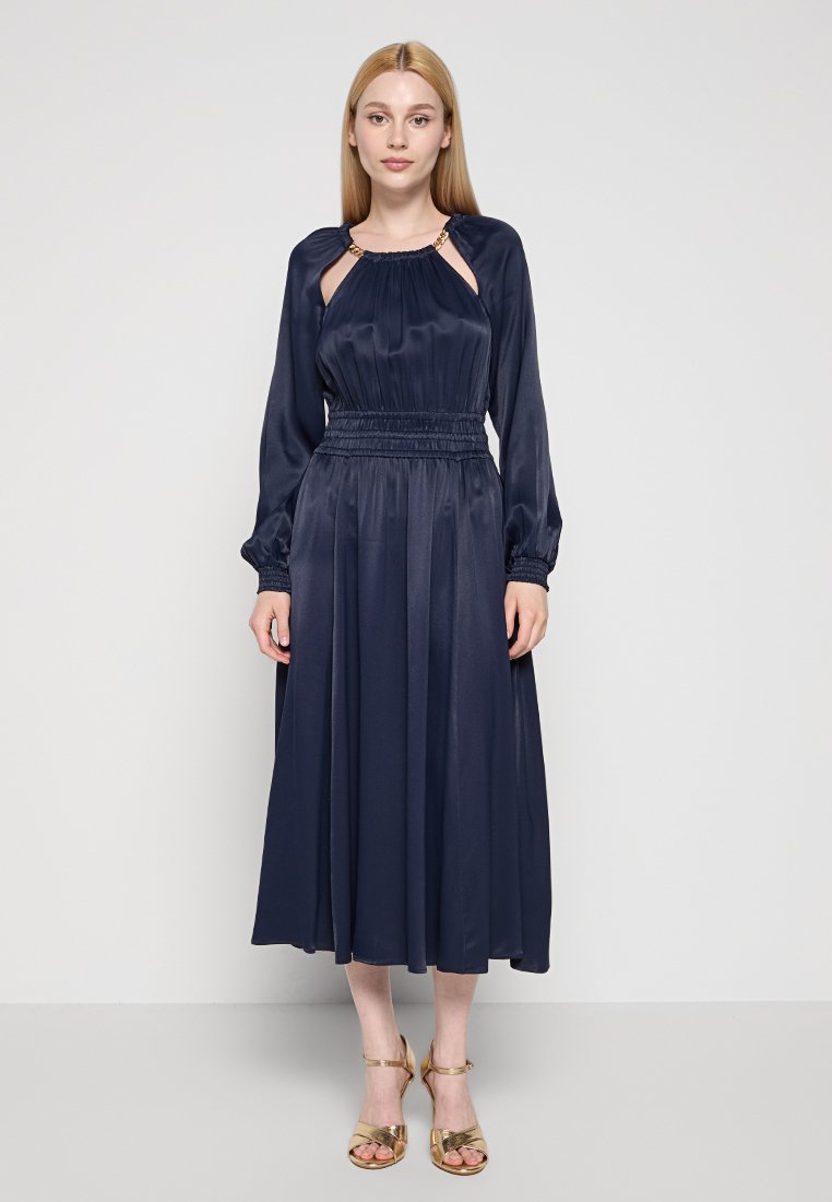 Lungo abito navy con maniche lunghe, vita arricciata e dettagli in oro al colletto, realizzato in un tessuto morbido e fluido.