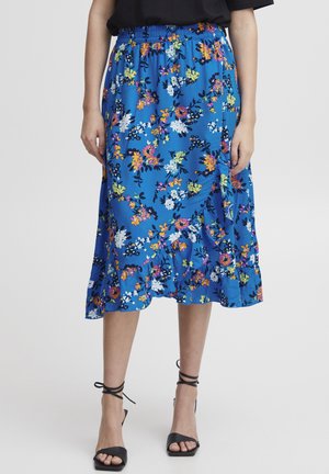 Floral midi skirt in vibrant blue fabric, featuring colorful flowers, an elastic waistband, and a ruffled hem. Paired with black heels.