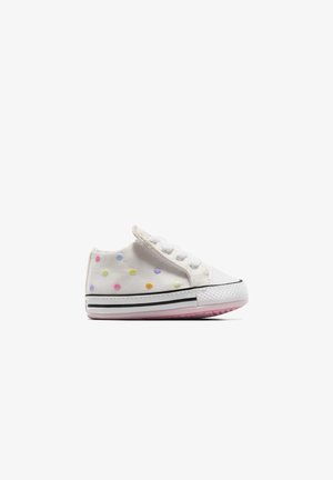 Weißer Sneaker für Kleinkinder mit pastellfarbenen, mehrfarbigen Punkten, weißen Schnürsenkeln und einer Sohle mit schwarzen Streifen, schräg dargestellt, um die Innenseite und die Sohle zu zeigen.