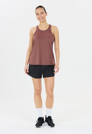 Marsala gestreiftes Tanktop mit einem runden Ausschnitt, kombiniert mit schwarzen Sportshorts, weißen Socken und schwarzen Turnschuhen. Glattes Material, lässiges Design.