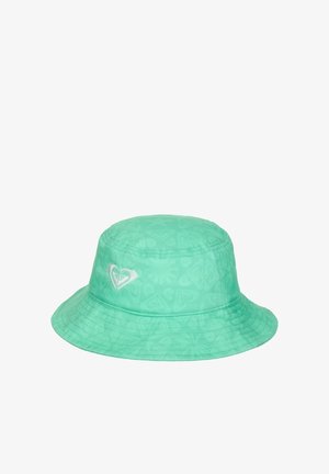 Sombrero tipo bucket verde hecho de tela suave, con un patrón sutil y un logo de corazón blanco en la parte delantera. El ala es ancha y plana.
