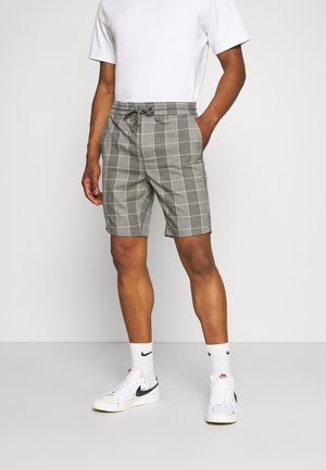 Gray plaid shorts with an elastic waistband and drawstring detail, featuring a straight cut and side pockets. Worn with white sneakers.
