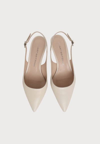 Paire d’escarpins slingback beiges à bout pointu avec brides à la cheville et boucles, vues de dessus sur fond blanc.