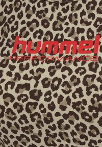 Leopardprint stof in tinten bruin en crème met gedurfde rode "hummel PERFORMANCE" tekst in het midden. Zachte, gestructureerde afwerking.