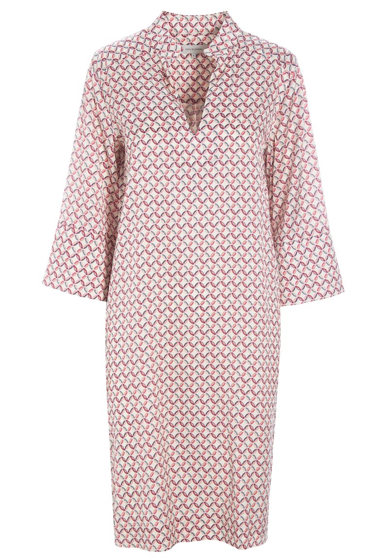 Tunique à motifs avec un décolleté en V et des manches trois-quarts, présentant un design géométrique en rose, rouge et bleu sur un fond blanc.