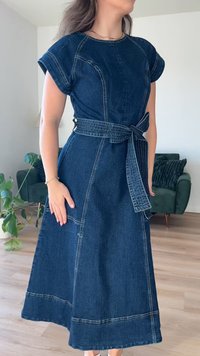 Vestido midi de mezclilla oscura con mangas cortas, cintura entallada con un cinturón a juego, con costuras en contraste y una falda fluida en forma de A.