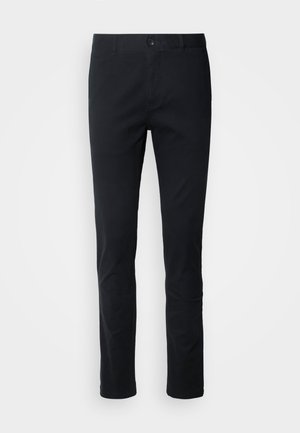 Pantalones negros de corte recto fabricados en una mezcla de algodón. Cuentan con un cierre de botones y trabillas para cinturón. Textura suave sin patrones visibles.