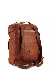 Zaino in pelle marrone con finitura testurizzata, dotato di cerniera principale, tasche laterali e spallacci regolabili. Patch quadrata con logo sulla parte anteriore.