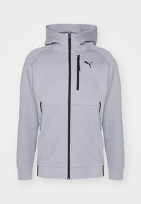 Felpa con zip di colore grigio chiaro, con colletto alto, dettagli neri e logo. Presenta una zip frontale, tasche e polsini e orlo a coste.