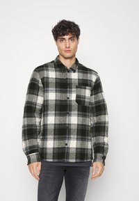 Schwarz-weiße karierte Flanellhemd mit button-down Kragen und einer Brusttasche, ausgestattet mit einem strukturierten Stoffdesign.