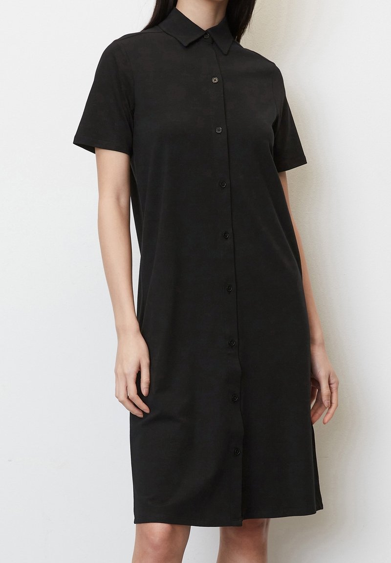 Svart knapp-up klänning i slät tyg, med krage, korta ärmar och rak klippning med knälång nederkant.