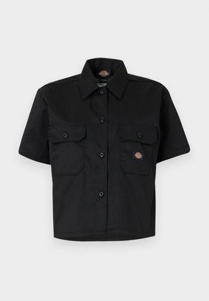 Lühikeste varrukatega must särk, mis on valmistatud töökindlast kangast, oma kahe suure esipocketiga ja nööpidega kaelusega.