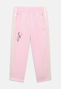 Pantaloni sportivi rosa con cintura elastica, strisce laterali bianche, ricamo floreale sulla gamba sinistra e tasche con zip.