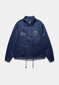 Navy blue satin jacket with zip front, collar, drawstring hem, embroidered text "Coldstone Path Division," and sports emblem on the chest.