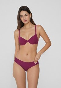 Fioletowy biustonosz i bikini z gładkiego materiału, regulowanymi ramiączkami oraz bezszwowym wzornictwem dla wygody i dopasowania.