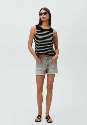 Black and white striped sleeveless top, cropped design, paired with light gray denim shorts and black flat sandals. Smooth texture, casual style.