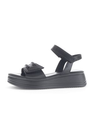 Black wedge sandals with a smooth texture, featuring a front strap with decorative hardware and an adjustable ankle strap.
