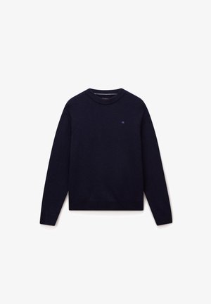 Marineblå strikket sweater med rund hals, lange ærmer og ribbede manchetter og kant. Har et lille logo på brystet.
