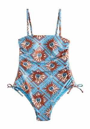 Blue one-piece swimsuit with adjustable straps and side ties, featuring a repeating sun and eye pattern in brown, white, and black.