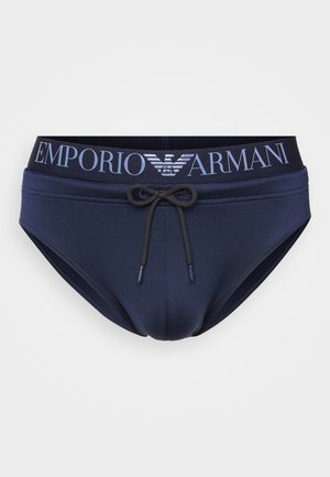 Slips de bain bleus avec cordon de serrage et taille élastique arborant le logo "Emporio Armani" en lettres claires. Texture de tissu lisse.