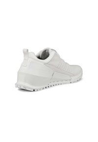 Vit idrottssko med en texturerad mesh-överdel, tunna perforeringar, vadderad krage och en hållbar gummisula med uttalade greppklackar.