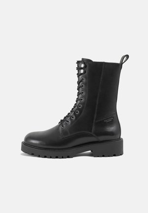 Schwarze Leder Schnürstiefel mit einer stabilen Gummisohle, ausgestattet mit einer glatten Oberfläche, runder Zehenform und einer Zuglasche hinten.