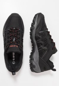 Black hiking shoes with a mesh and synthetic upper, textured rubber outsole, padded collar, and red accent laces.