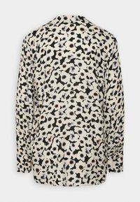 Maglietta a maniche lunghe con motivo floreale in nero, bianco e rosa chiaro, dalla vestibilità morbida e con una texture di tessuto liscia.